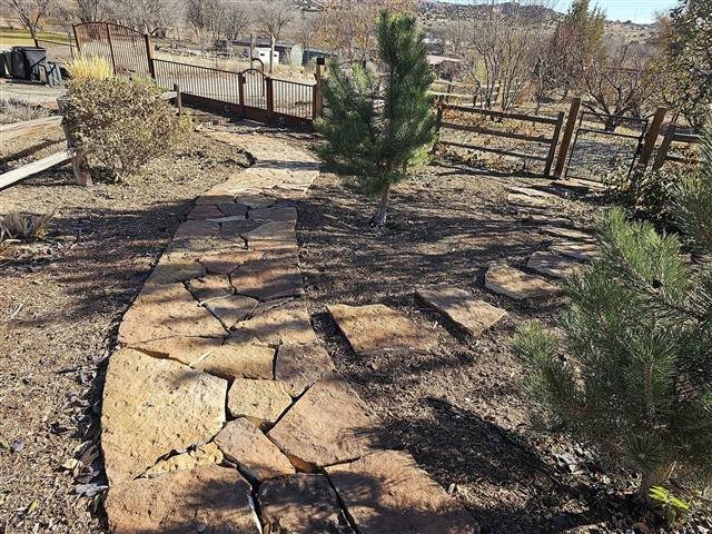 Flagstone walkway through a landscaped yard