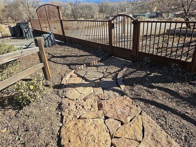 Stone path leading to an iron gate